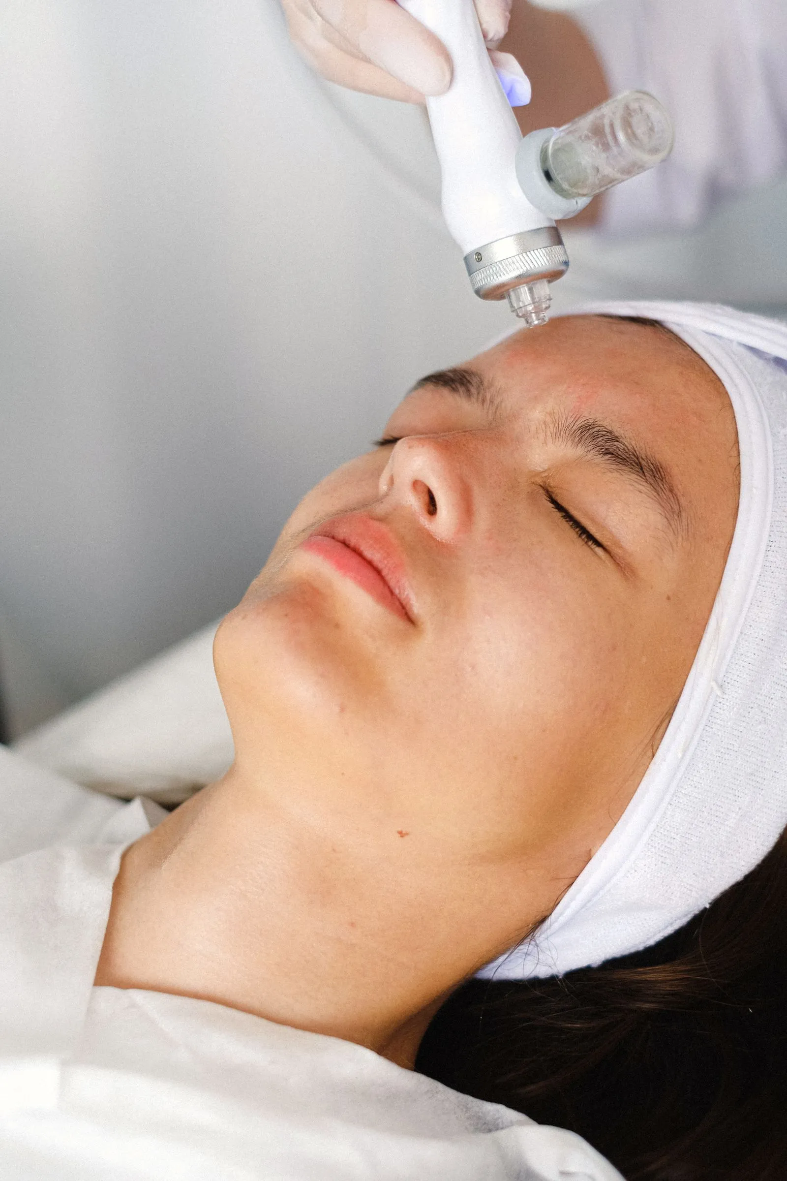 A client relaxing during a skin treatment with a handheld device